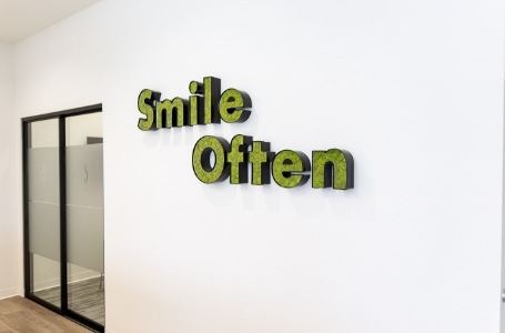 Sign reading smile often on dental office wall