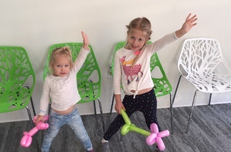 Two children dancing in dental office waiting room