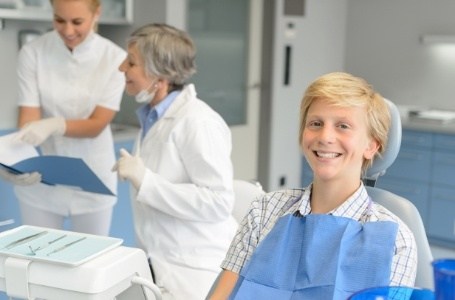 Smiling preteen boy in dental chair for preventive dentistry