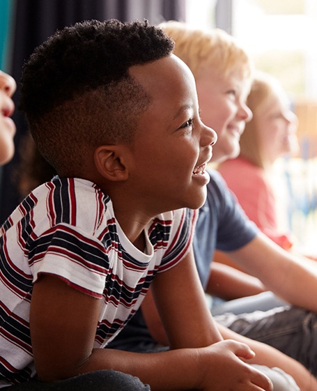 children lined up and sitting on the floor in a classroom