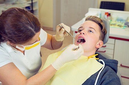 a teenager having their mouth examined by a dentist
