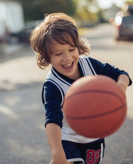 Young patient playing basketball after children's dentistry visit