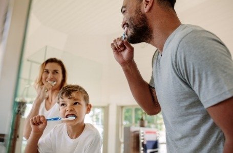 Family brushing teeth to prevent dental emergencies