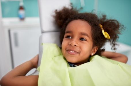 Child relaxing as parents discuss the cost of dental emergencies