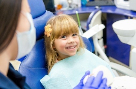 Child smiling after supernumerary tooth extractions
