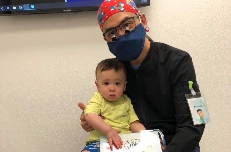 Dentist holding baby during dentistry for infants visit