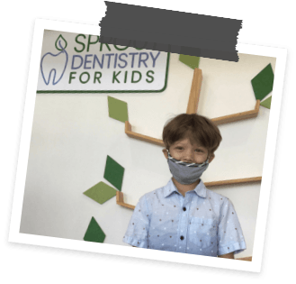 Child wearing face mask in front of Sprout Dentistry for Kids of Allen sign