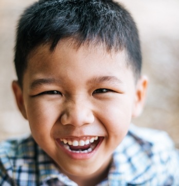 Young boy with plaid shirt grinning