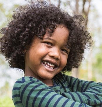 Child with curly hair grinning