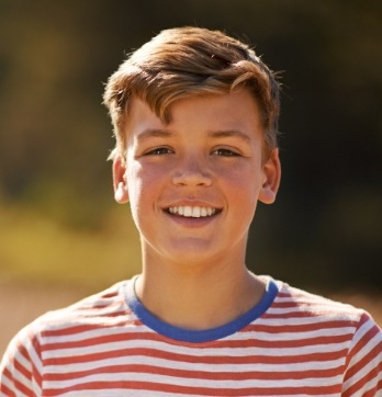 Preteen boy smiling outdoors