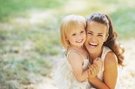 Mother and daughter smiling outdoors