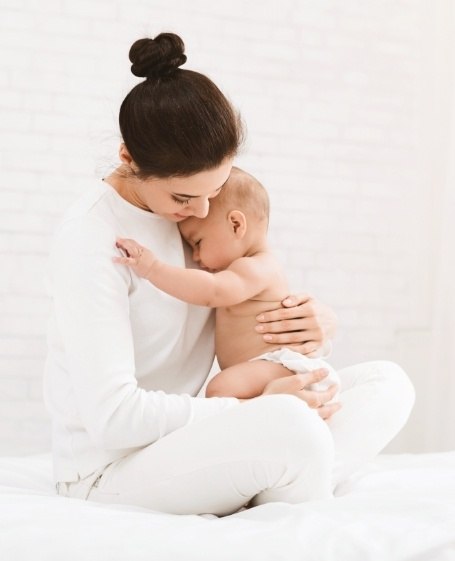 Mother holding infant after lip and tongue tie treatment