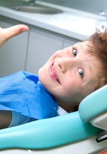 child giving thumbs up while visiting dentist 