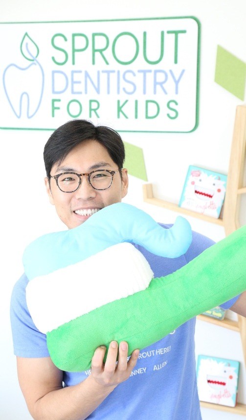 Doctor Yoo holding an oversized novelty toothbrush