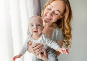 Mother holding baby after lip and tongue tie treatment