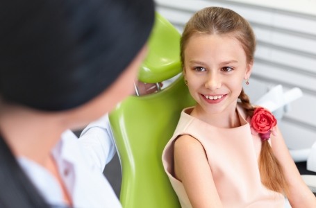 Child smiling after receiving a one-visit dental restoration
