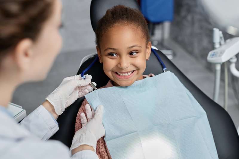 A child smiling before their silver diamine fluoride treatment at the dentist