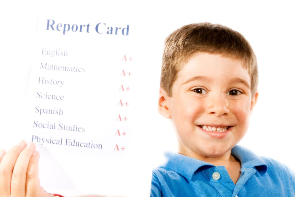 Little boy holding straight A+ report card