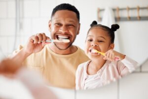Dad brushing his teeth with his daughter
